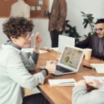 Business meeting with colleagues discussing data on a laptop in an office.